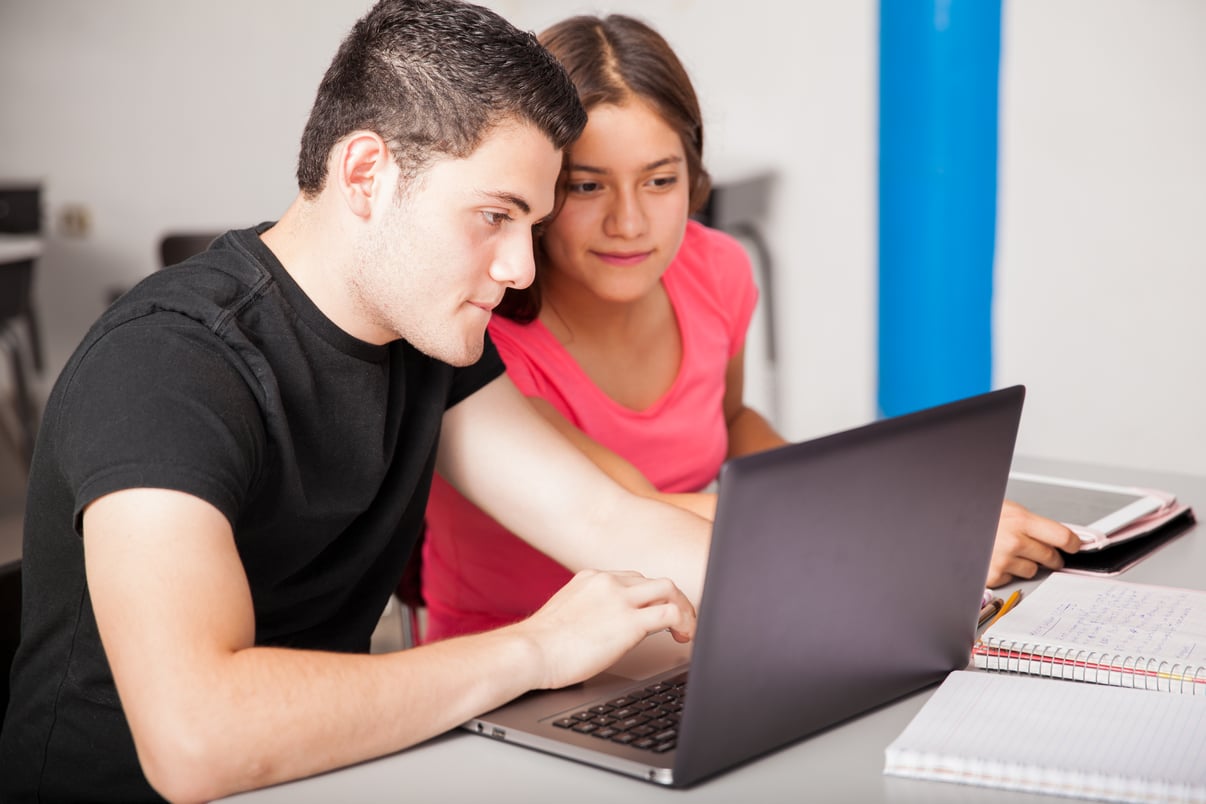 couple-hispanic-teenagers-stuying-using-laptop-together-school