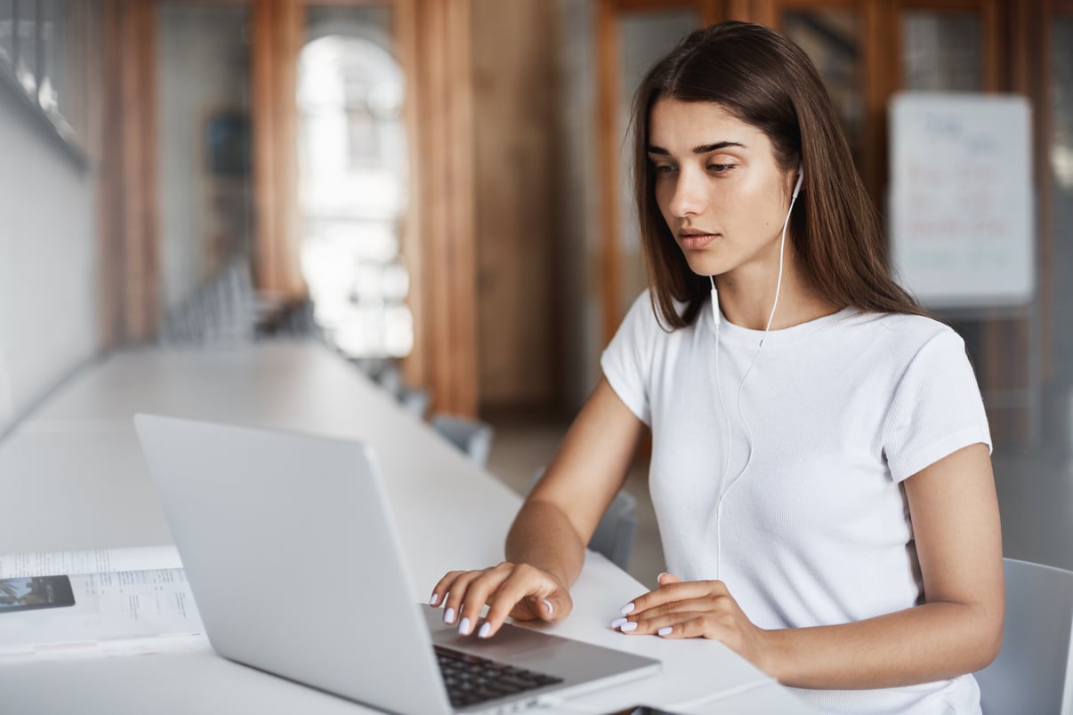 mujer-joven-usando-computadora-portatil-viendo-peliculas-tiempo-real-o-escuchando-musica-linea-campus-universitario